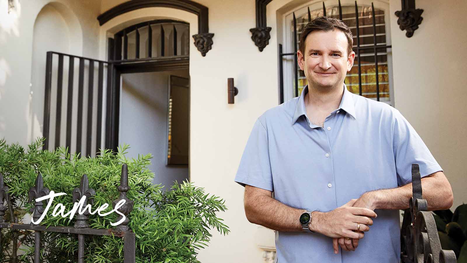 James smiling in front of house